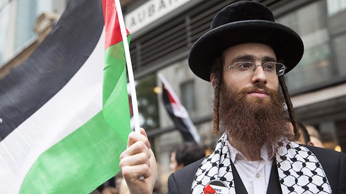 An ultra-Orthodox Jew holds a Palestinian flag during a protest against Israel’s air strikes in Gaza in London July 11, 2014. (Reuters / Neil Hall)