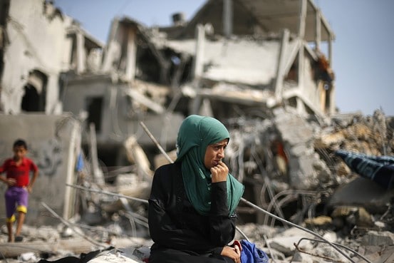 A Palestinian woman sits on the remains of her destroyed house Tuesday after returning to Beit Hanoun town, which witnesses said was heavily hit by shelling and air strikes during the Israeli offensive. Reuters