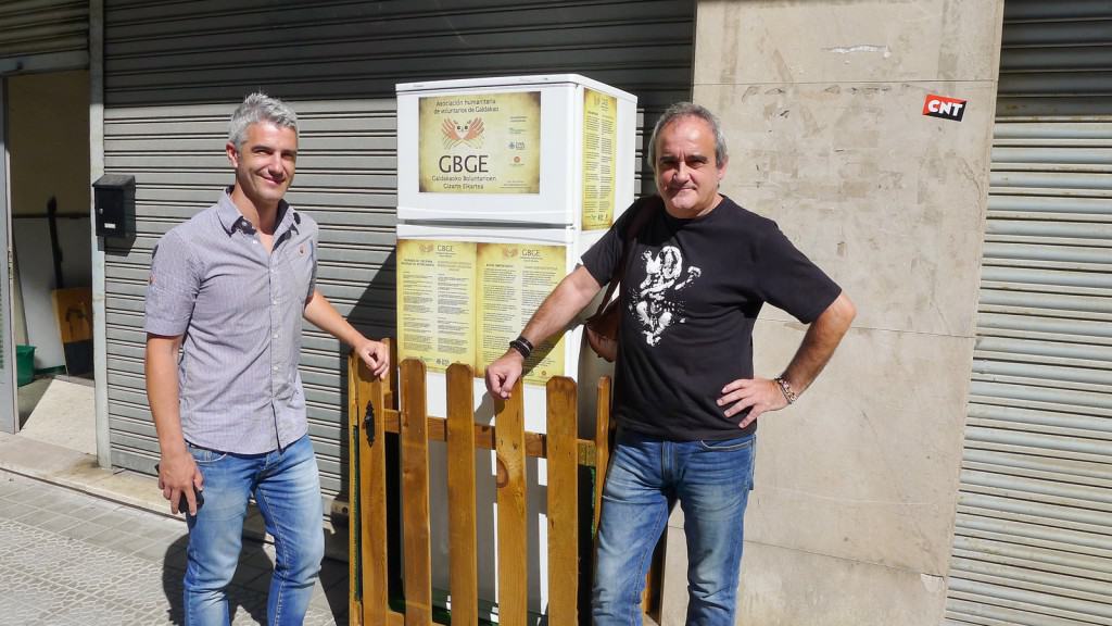 The mayor and a volunteer in front of the "Solidarity Fridge" installed to feed the hungry.  Credit: NPR