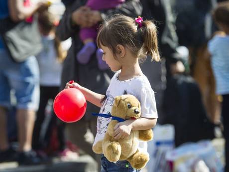 A little girl with a balloon and a teddy bear. Credit: Independent UK