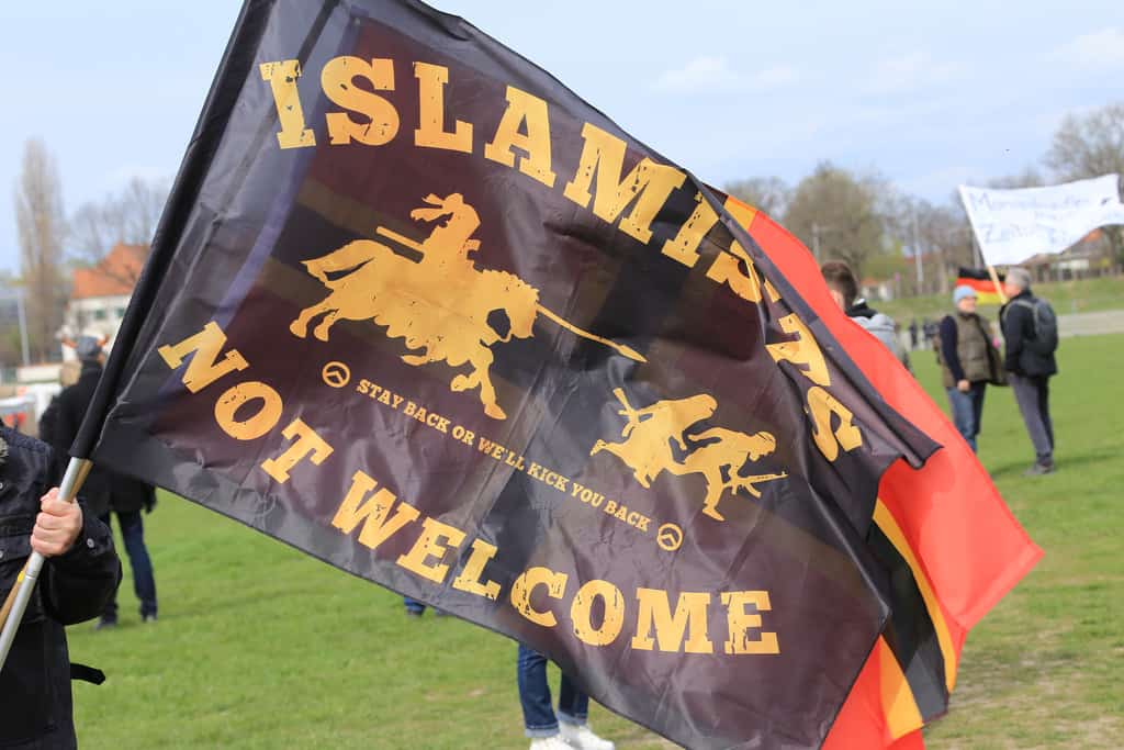 A flag of German far-right movement Pediga with the message "Islamists not welcome". Credit: CC, Flickr, metropolico.org