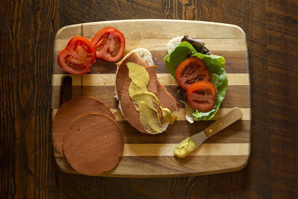 A meatless bologna deli sandwich, “made without the mystery.” Credit: The Herbivorous Butcher